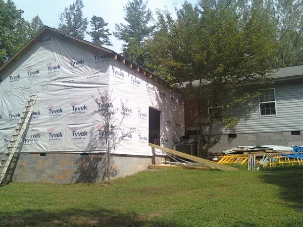 Tyvek wrapped gable on a new room addition beside an existing home in Utica